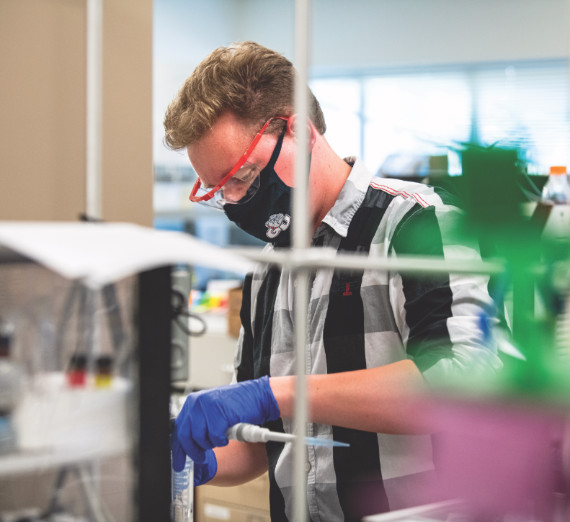 Dos personas estudian una planta en una invernadera.
